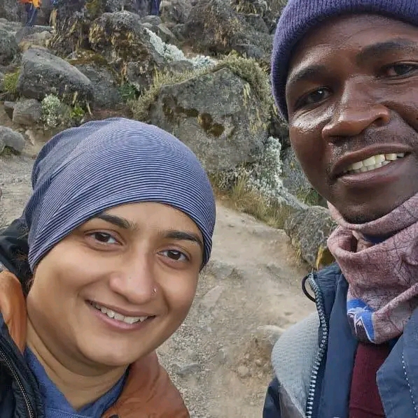 Geofrey Clemence Mwakamele with a guest on a rocky mountain trail in Tanzania